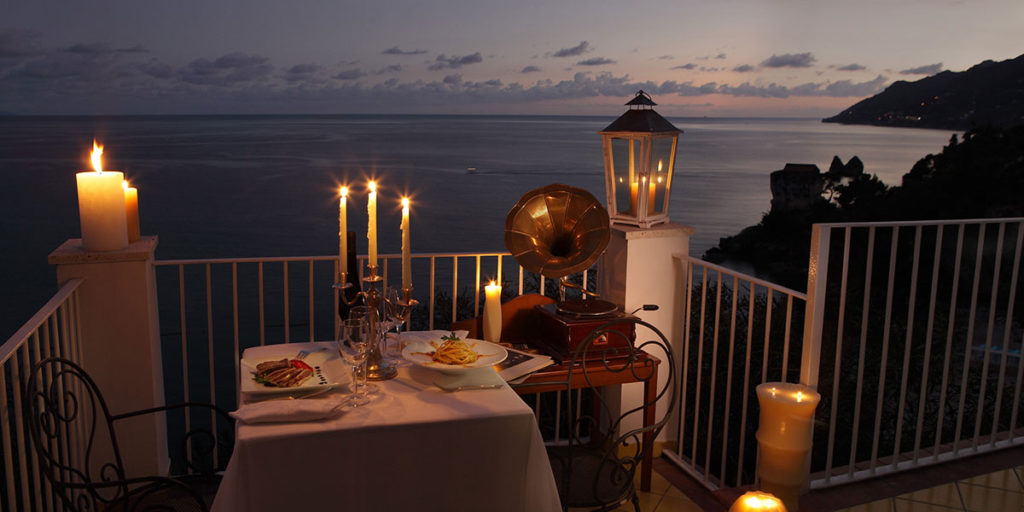 tavolo apparecchiato terrazza sul mare lume di candela